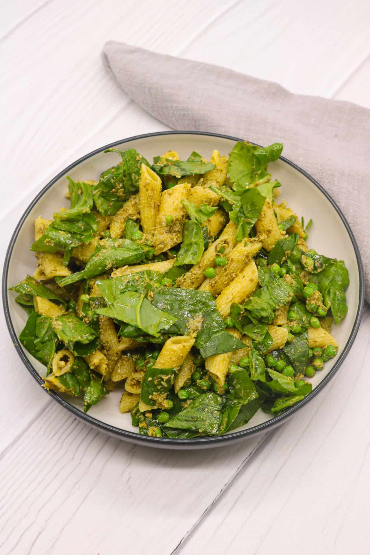 Pesto, peas and spinach pasta salad in large bowl