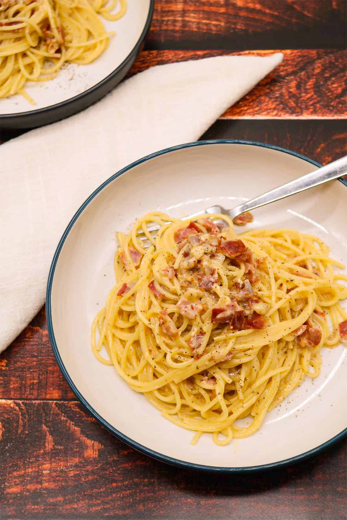 Spaghetti carbonara in bowl with fork