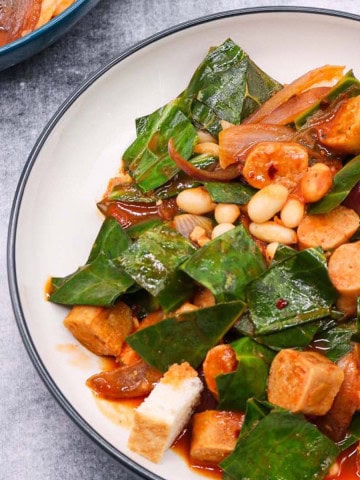 Close up of a bowl of vegan sausage and white bean stew.