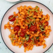 Chorizo and chilli pepper pasta in a black and cream bowl.