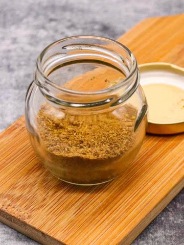 fajita seasoning in a jar on wooded board