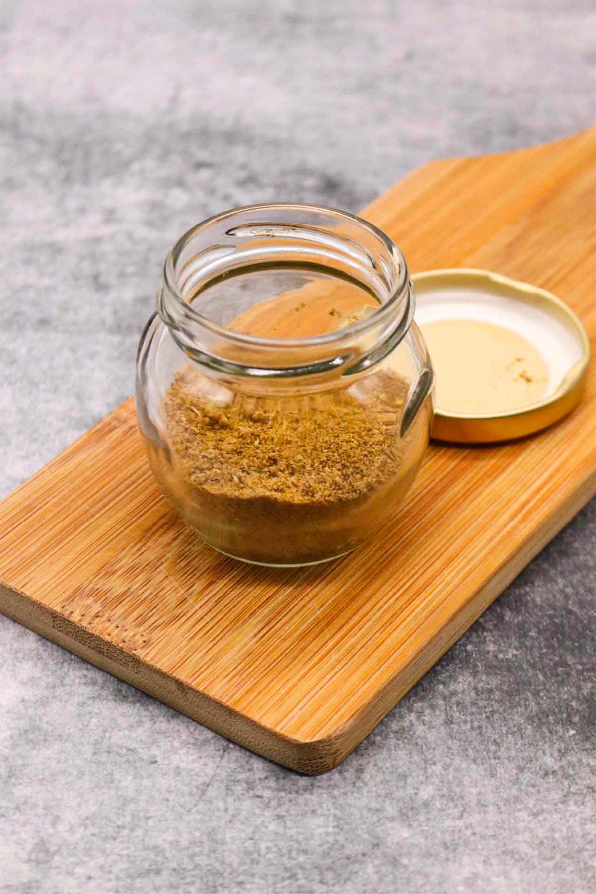 fajita seasoning in a jar on wooded board