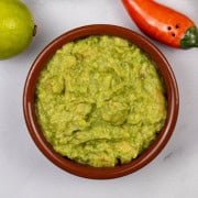 Guacamole in a terracotta serving dish.