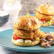 Buffalo turkey cheeseburger and coleslaw on a teal dinner plate.