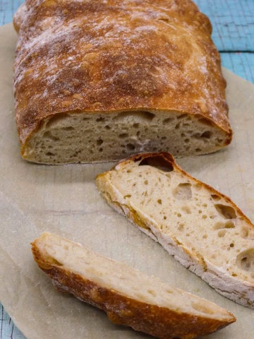 Ciabatta bread sliced on baking paper