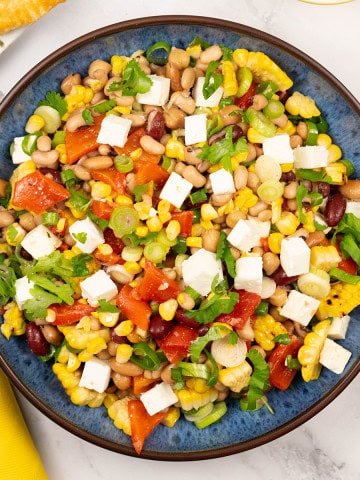 Grilled sweetcorn salad with feta in a blue serving bowl.