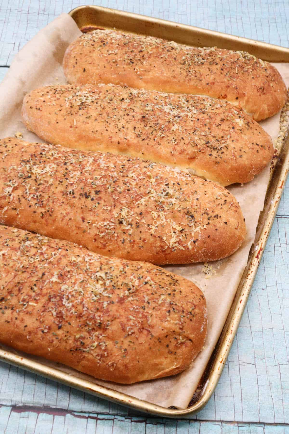 Italian herb sub rolls on baking tray