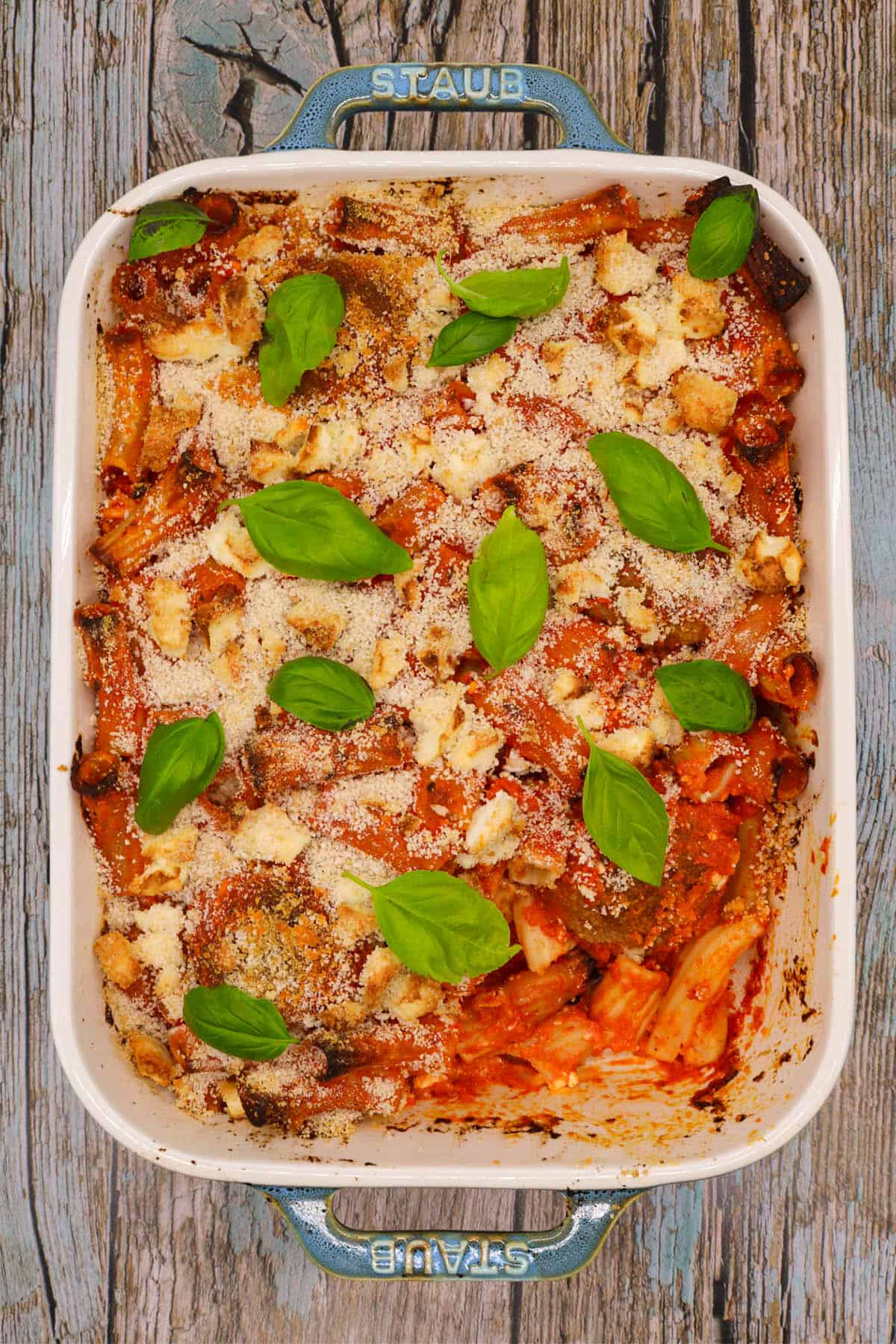 Lamb meatball, red pepper and feta bake in large rectangle oven dish with basil leaves