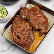 Perfect sirloin steaks resting on a tray.