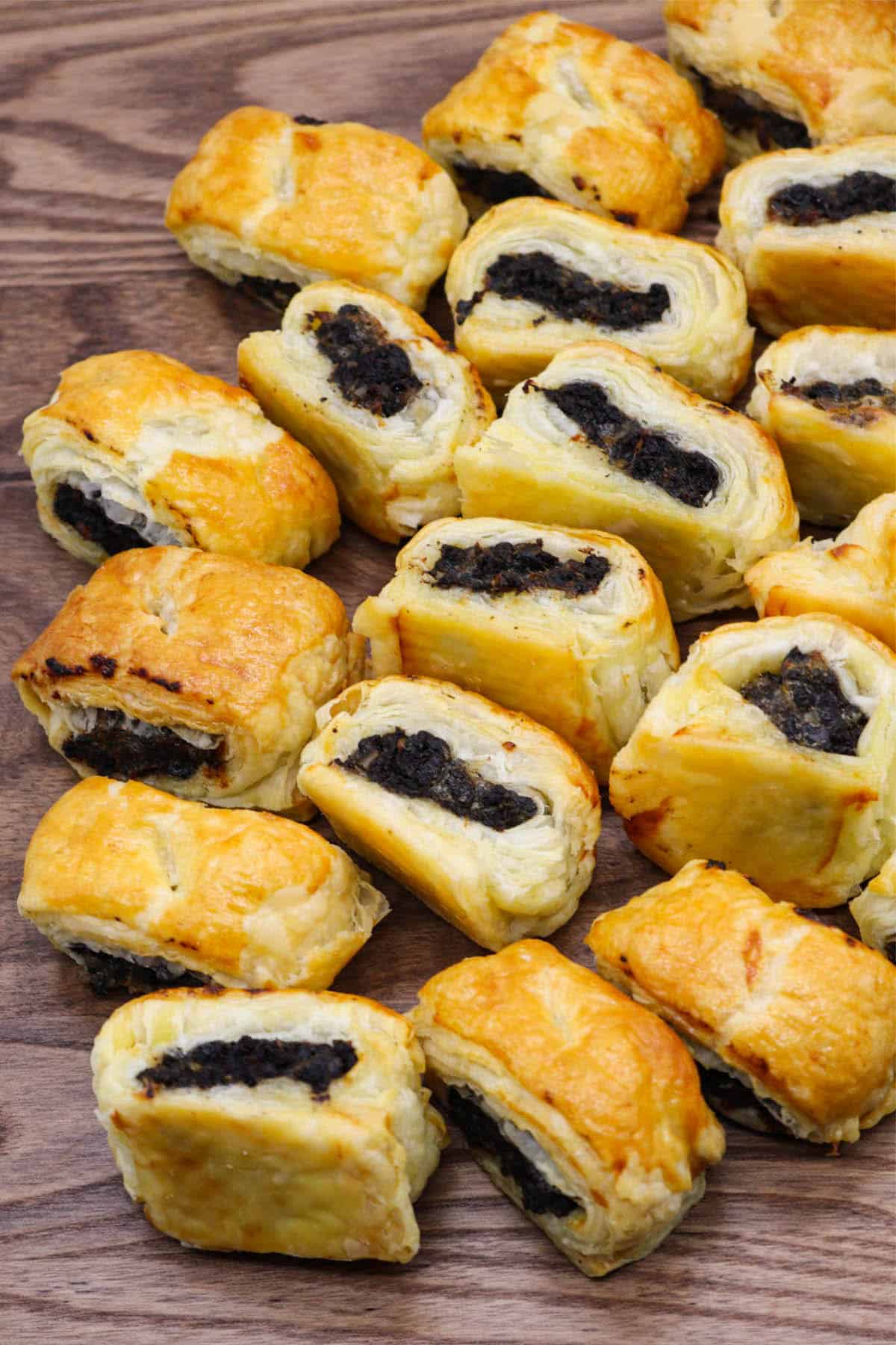 Pork and black pudding sausage rolls on wooden board