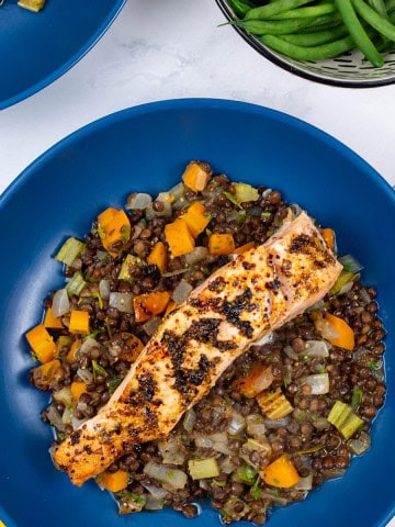 Two bowls of salmon with vegetable puy lentils, plus a dish of quick green beans on the side.