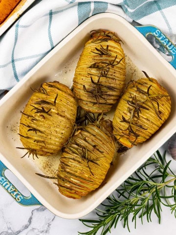 4 garlic and rosemary hasselback potatoes in a Staub ovenproof dish.