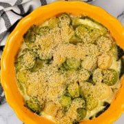 Leek gratin in a round yellow ovenproof dish.