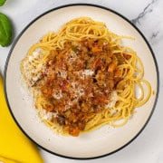 A bowl of lentil and vegetable bolognese with spaghetti.