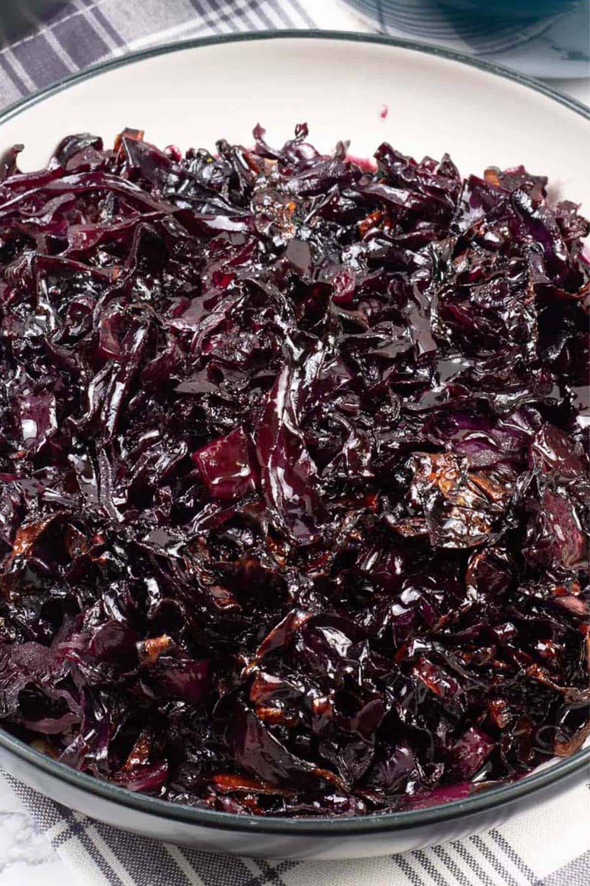 Braised red cabbage in a black and cream serving bowl.