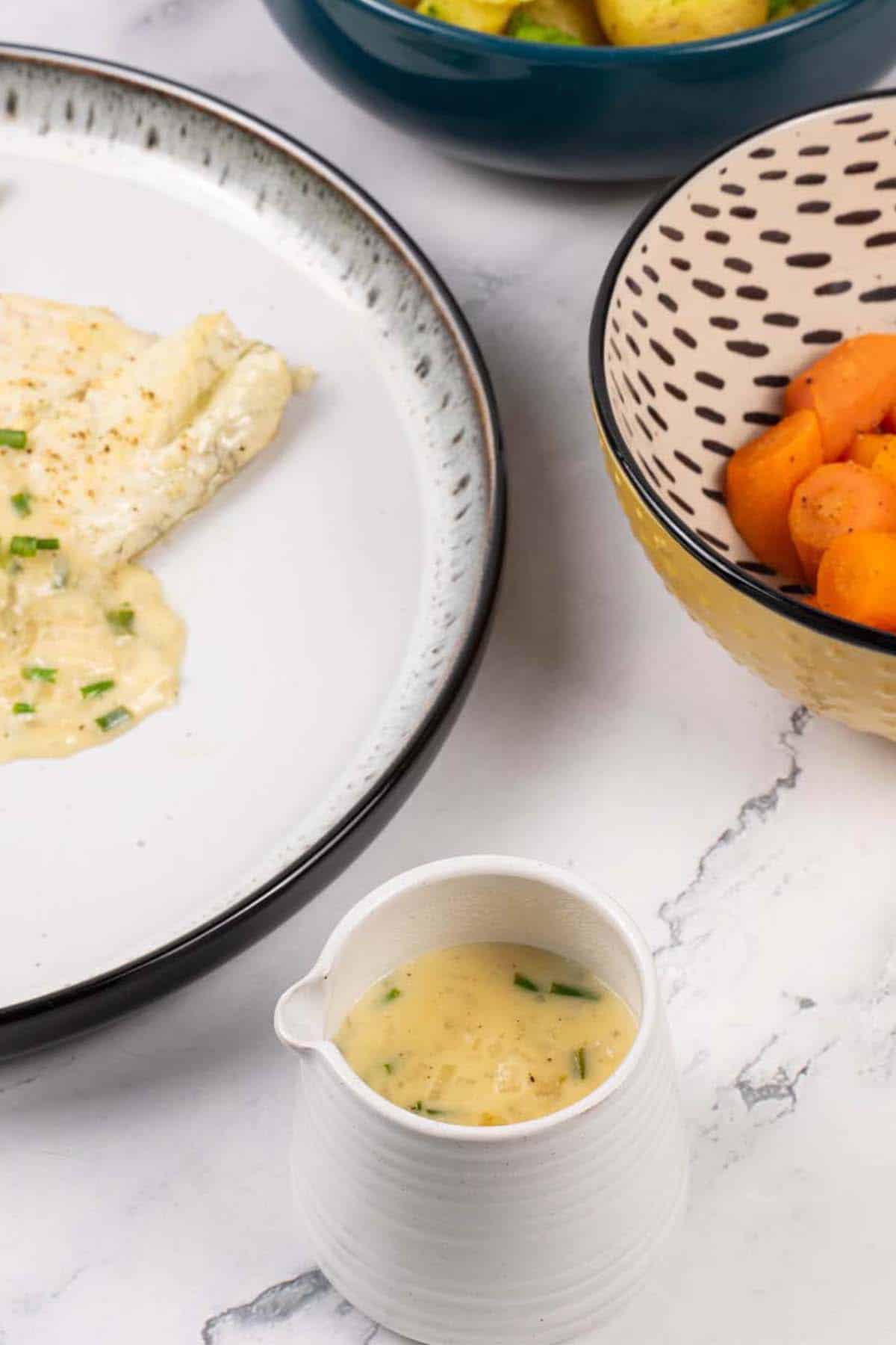 White wine and cream sauce in a small white jug.