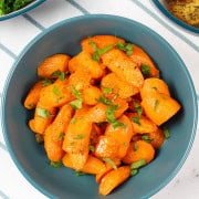 Marmalade roast carrots in a teal serving bowl.