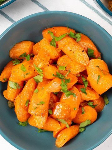 Marmalade roast carrots in a teal serving bowl.