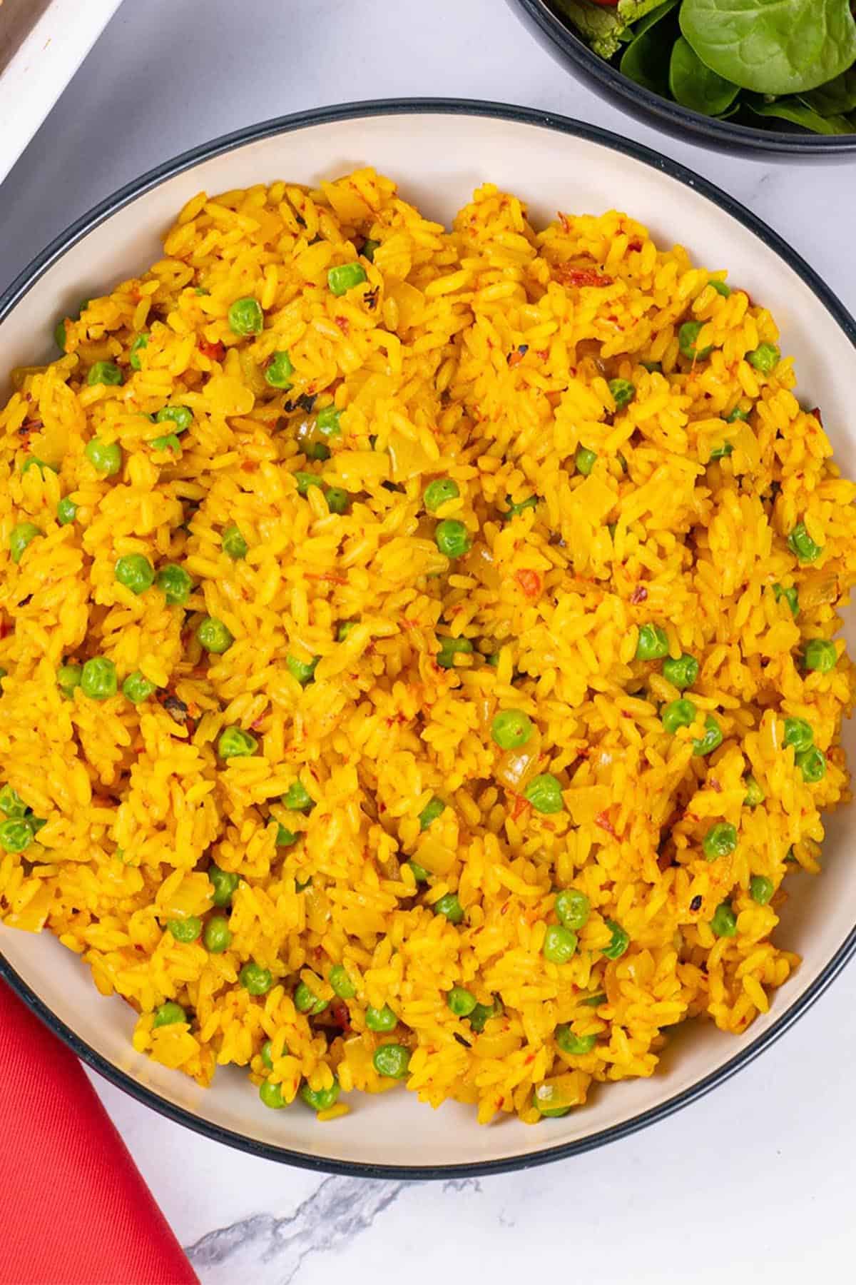 Nando's spicy rice in a black and cream serving bowl.