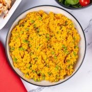 Nando's spicy rice in a black and cream serving bowl.