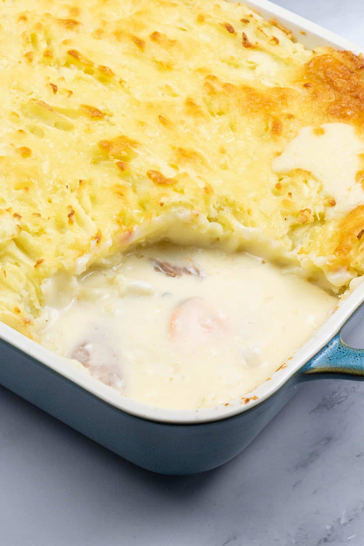 Close up of fish pie in a rectangular ovenproof Staub dish.