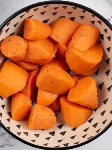 Quick cook carrots in a black and cream patterned serving bowl.