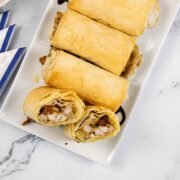 Chicken, mozzarella and pesto filo parcels on a white rectangular serving platter.