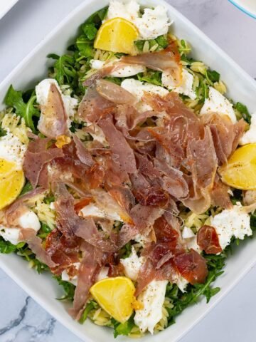 Crispy prosciutto and orzo salad in a white square serving dish.