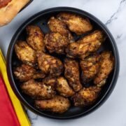 Easy air fryer Spanish chicken wings in a black serving bowl.