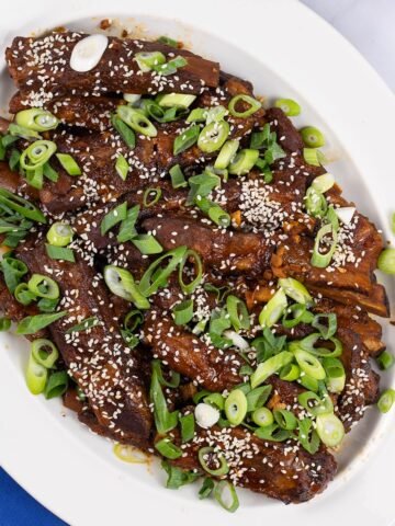 Slow cooker gochujang pork ribs on an oval white platter.